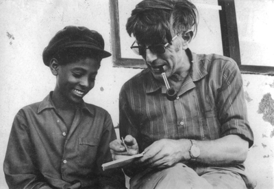 230148 Pater G.J. Essing onderwijst een jongen op een missiepost in Ethiopië