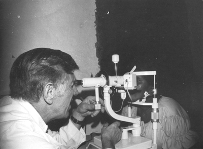 230151 Pater G.J. Essing bezig met een oogonderzoek in de missie (Ethiopië)