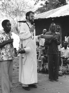 140020 Een pater spreekt tijdens een fancy-fair voor de bekostiging van een nieuw dak voor een dorpskerk in Uganda