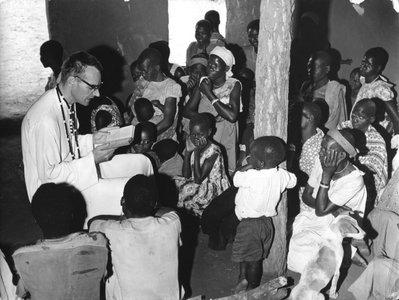 140029 Missionaris leest voor uit de bijbel in de Giulemé Missie in Malawi