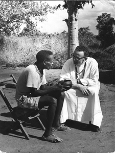 140030 Missionaris Louis Roelers in gesprek met een dorpsbewoner in Malawi