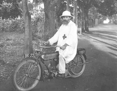 140058 Broeder Willybald (Mathieu Biesbroeck) op zijn motorfiets in de missiepost te Kagando in Uganda