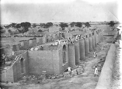 140204 De buitenmuren worden opgetrokken van de kathedraal in Ouagadougou, met rechts toeziende bouwbroeder Constantin ...