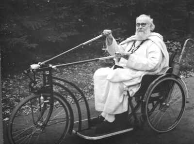 140260 Pater R. van der Vliet van de Witte Paters in zijn rolstoelfiets in St. Charles te Esch