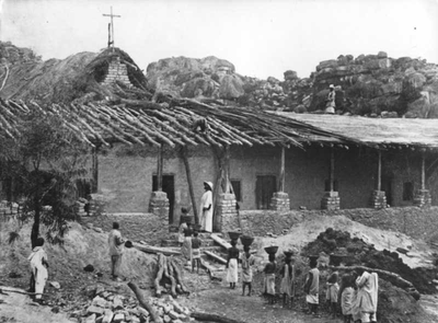 140348 Missionarissen werken samen met catechumen en wezen aan de constructie van een missiepost te Kamoga in Tanzania