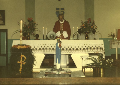 140436 Pater Hans Peters gaat voor in de mis met brandende paaskaars en speciale madonna te Mabamba in Uganda
