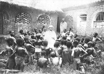 140460 Pater Alfons van Sambeek tijdens drie weken catchismusles aan een groep Afrikaanse christelijke jongens in de ...