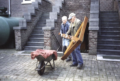 140653 Broeders Van Zutphen en Van Dijk gaan een opgeknapt houten kruis herplaatsen in de tuin van St. Charles te Heythuysen