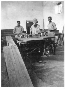 140669 Broeder Fulgence met hulpen in de timmerwinkel te Tanganyika (tegenwoordig: Tanzania)