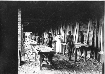 140734 Pater Oomen in de plankenschaverij van de leer-/werkplaats voor Afrikaanse werknemers te [Mulera?]