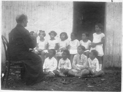 208568 Pater van Dinteren geeft onderricht in Brazilië
