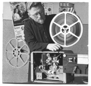 218051 Pater Wim Wammes met de filmprojector