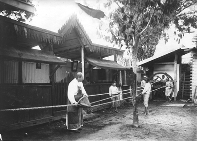 186620 Touwen worden gespannen bij de touwslagerij van het jongensweeshuis in Suriname