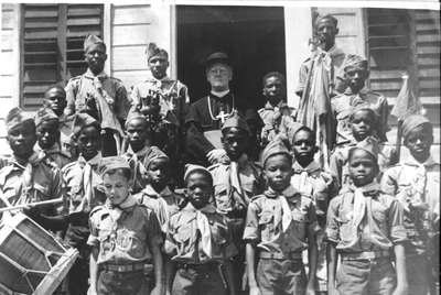 186631 Monseigneur van Roosmalen wordt feestelijk ontvangen door de verkenners te Nieuw-Nickerie (Suriname)