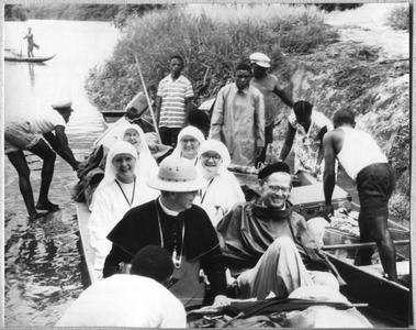 186660 Monseigneur Kuijpers in een korjaal op reis met pater A. Donicie en vier missiezusters (Suriname)