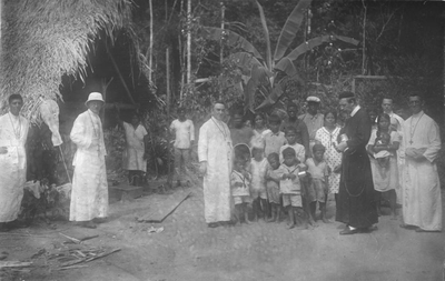 186859 Suikergoed uitdelen aan de lokale bevolking (Suriname)