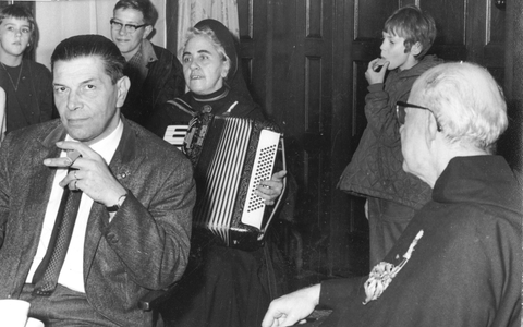 102061 Zuster Huberta speelt op haar accordeon tijdens de receptie van een jubilerende pater