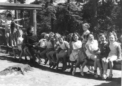 102081 Zuster Marie met kinderen uit Amsterdam in de speeltuin op de familieschommel