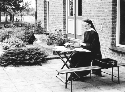 200015 Met mooi weer wordt het kantoorwerk naar buiten verplaatst in de priorij te Heesch