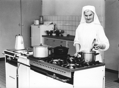 216008 Zuster bereidt de maaltijd in de priorij Fons Vitae te Heesch