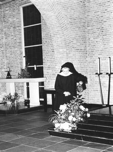 216017 Zuster verzorgt de planten en bloemen in de kapel te Heesch
