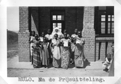 242051 Groepsfoto na een prijsuitreiking aan schoolmeisjes in missiepost Mulo, Congo