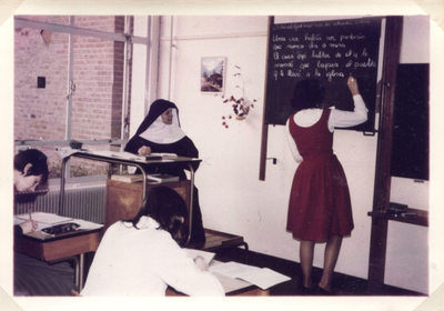 242084 Zuster van de Dochters van O.L. Vrouw geeft Spaanse les aan de ULO aan de Dobbelmannweg te Nijmegen