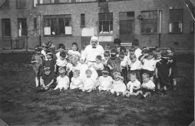 196040 Zuster Catharina van de communiteit Magdalena te Overschie met de kinderen van hun kleuterschool
