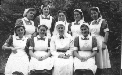196050 Groepsfoto van moeder Hyacintha van der Schans de la Croix omringd door gezinsverzorgsters van het internaat ...