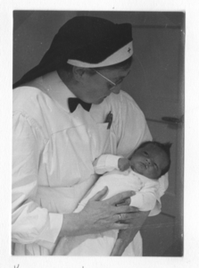 196090 Zuster Maria van der Valk met baby op haar arm te Nijmegen