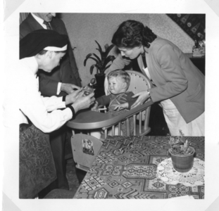 196094 Zuster Maria van der Valk verleent hulp bij een gezin in Nijmegen
