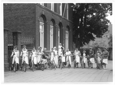 196119 Bij Huize Bethlehem te Roermond staan dertien gezinshulpen klaar met de fiets om in de stad aan het werk te ...