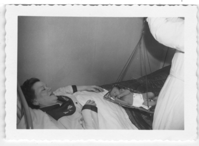 196122 Een zuster van de kraamzorg te Nijmegen weegt pasgeboren baby