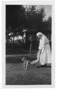 196219 Zuster Maria van de Valk speelt in de tuin met een jongen