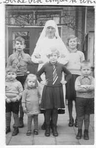 272010 Zuster van de Dominicanessen van het Sint Catharina-Apostolaat te midden van moederloze kinderen, vermoedelijk ...