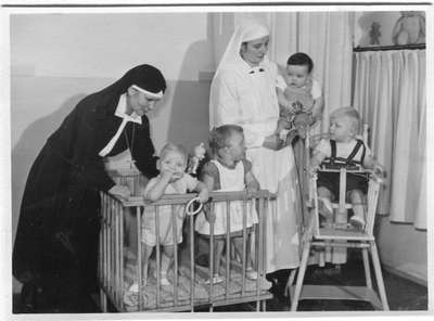 272023 Moeder Paula en zuster Lucia met kinderen in de kleuterkamer van een huis van de congregatie, vermoedelijk te ...