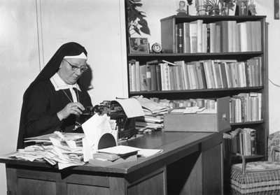 272043 Moeder Rosa van de Dominicanessen van het Sint Catharina-Apostolaat aan het werk achter een typemachine te Wageningen