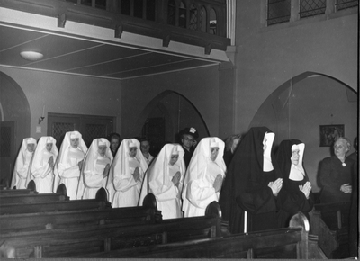 250337 Moeder M. Siegberta en zuster M. Leonarde geleiden zusters die naar de missie vertrekken naar het altaar van ...