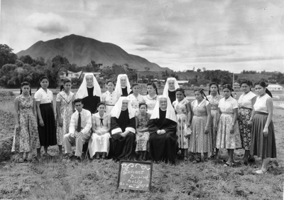 250345 Groepsfoto van zusters en leerlingen van (vermoedelijk) een school van de congregatie te Balige (Indonesië)