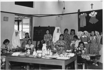 250353 Zuster Cunera en zuster Melania met leerlingen van de naaischool van de congregatie, vermoedelijk te Tandjung ...