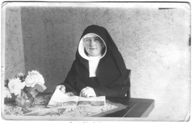 252333 Zuster Lucretia Sinack aan tafel met een tijdschrift