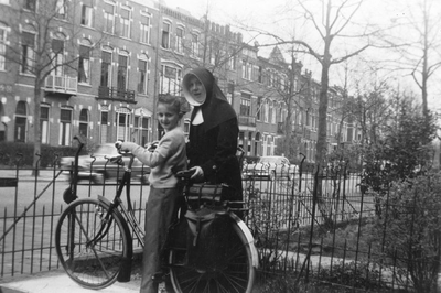 178271 Zuster Caritas, gaat met de fiets op pad als wijkverpleegster