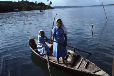 178348 Zuster in een bootje op weg om te gaan verplegen en les te geven in hygiëne te Batam (Indonesië)