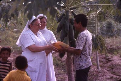 178350 Zusters geven een papaya aan een lokale bewoner van Galang (Indonesië)