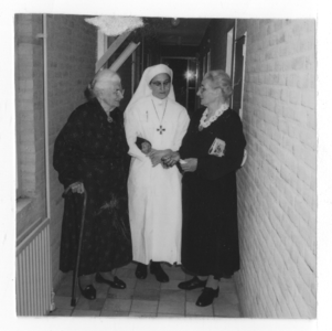 178454 Zuster in gesprek met bejaarden in het ziekenhuis te Breda