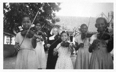 184149 De interne leerlingen van de Voorzienigheidsschool krijgen vioolles te Paramaribo (Suriname)