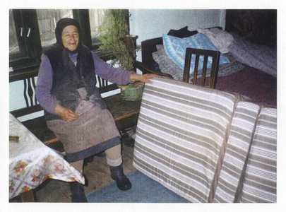 170380 Een bejaarde vrouw in Roemenië krijgt een nieuwe matras