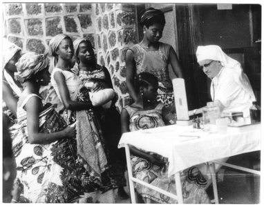 206135 Zuster Susanne Terrens tijdens haar werkzaamheden als vroedvrouw op het consultatiebureau voor zwangere vrouwen ...