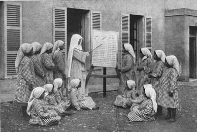 116053 Een Witte Zuster geeft onderricht aan weeskinderen in Uganda