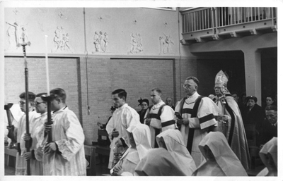 116113 Binnenkomst van de geestelijkheid in de kapel, onder wie mgr. C. Bronsveld, voor een plechtigheid van inkleding ...